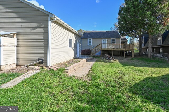 rear view of house with a lawn, fence, stairway, and a deck