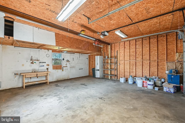 garage with a garage door opener and a workshop area