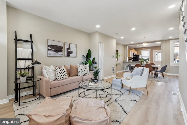 living room featuring baseboards, wood finished floors, and recessed lighting