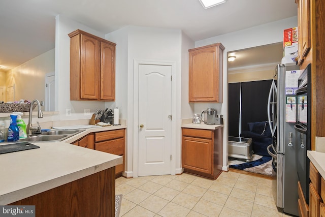 8509 Lexington Dr, Severn, MD 21144 - kitchen featuring light countertops, a sink, light tile patterned floors, and brown cabinets