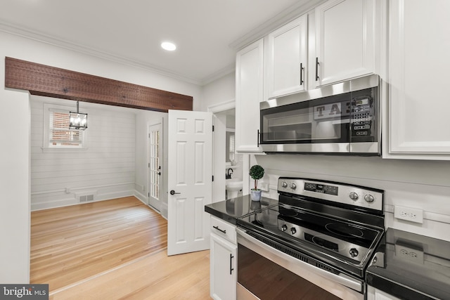 512 Dunlap St, Winchester, VA 22601 - kitchen with stainless steel appliances, ornamental molding, white cabinetry, light wood-style flooring, and dark countertops