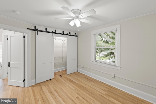 512 Dunlap St, Winchester, VA 22601 - unfurnished bedroom with a barn door, ornamental molding, light wood-type flooring, baseboards, and a closet