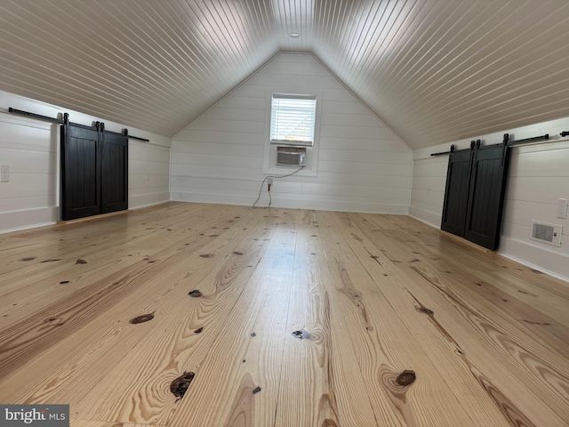 512 Dunlap St, Winchester, VA 22601 - additional living space featuring a barn door, vaulted ceiling, hardwood / wood-style flooring, cooling unit, and wooden walls