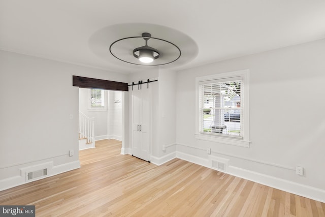 512 Dunlap St, Winchester, VA 22601 - spare room with a barn door, light wood-style flooring, healthy amount of natural light, and baseboards