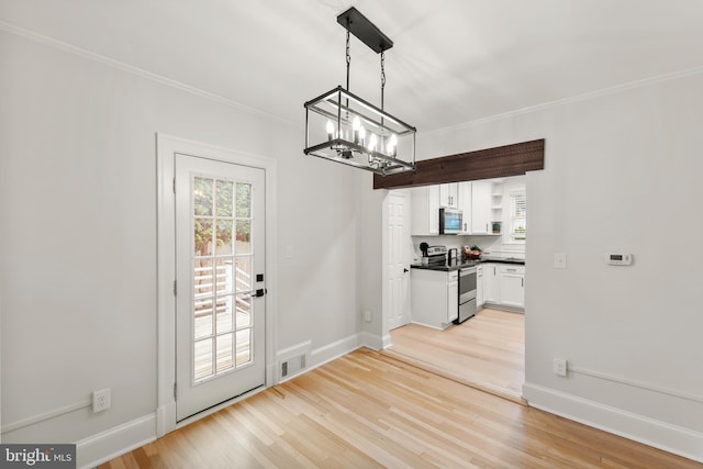 512 Dunlap St, Winchester, VA 22601 - unfurnished dining area with a chandelier, light wood-type flooring, crown molding, and baseboards