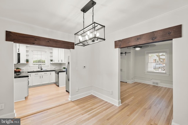 512 Dunlap St, Winchester, VA 22601 - unfurnished dining area with a chandelier, light wood finished floors, a sink, baseboards, and ornamental molding