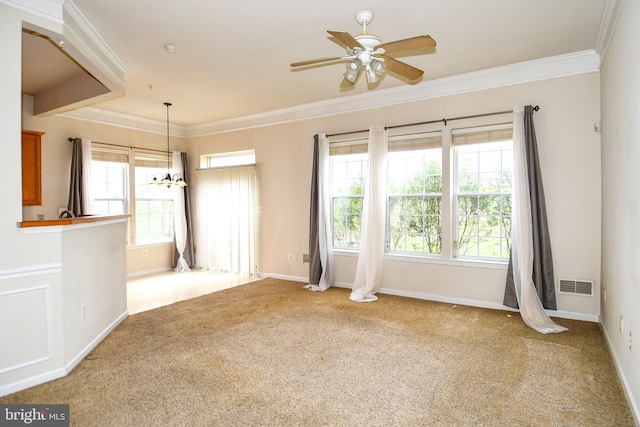carpeted empty room featuring ceiling fan with notable chandelier, baseboards, ornamental molding, and visible vents