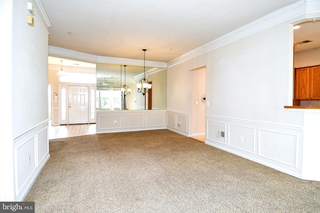 unfurnished dining area with a decorative wall, ornamental molding, visible vents, a wainscoted wall, and carpet floors