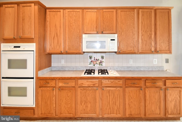 kitchen with brown cabinets, light countertops, white appliances, and decorative backsplash