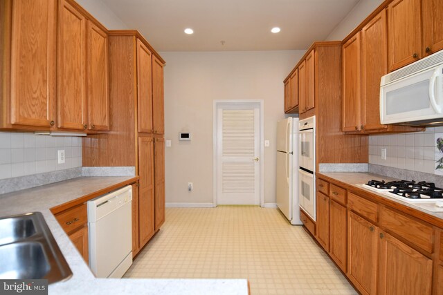 kitchen with brown cabinets, light countertops, and white appliances