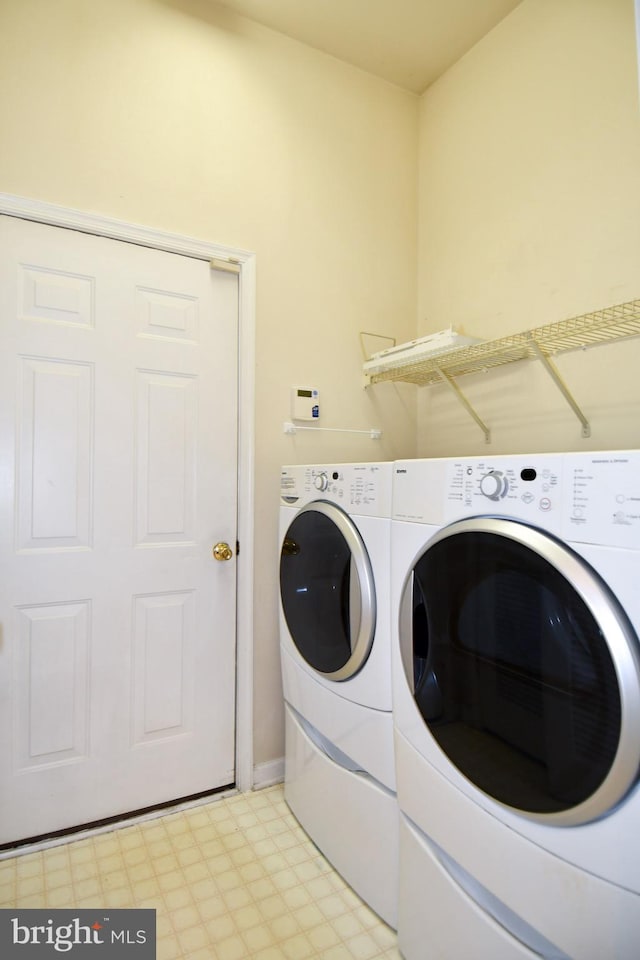 clothes washing area featuring independent washer and dryer, light floors, and laundry area