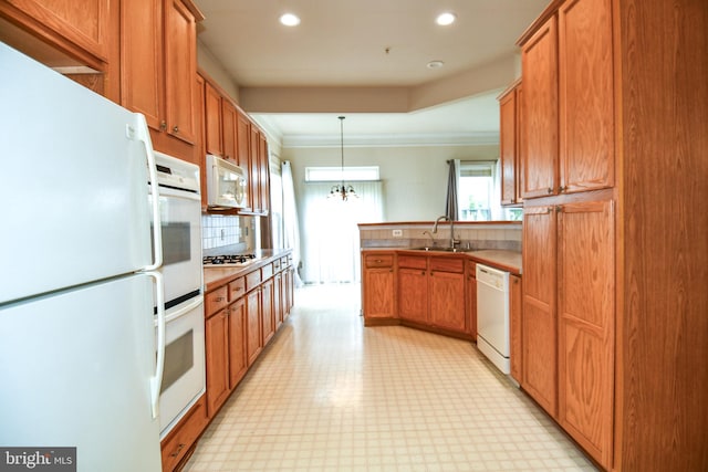 kitchen featuring white appliances, a sink, a peninsula, and light floors