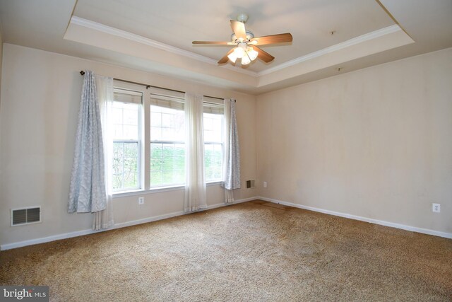 spare room featuring visible vents, carpet floors, a ceiling fan, and a raised ceiling