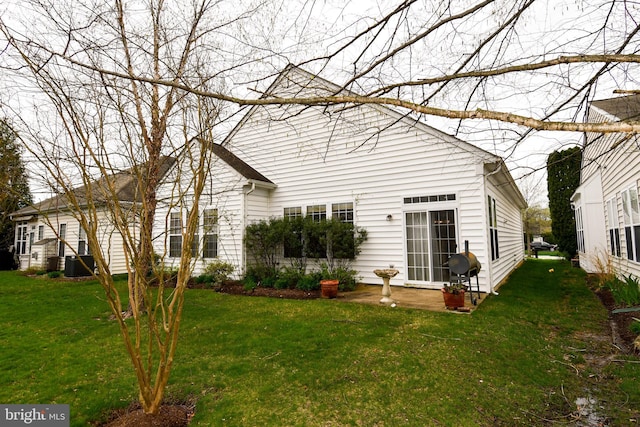 rear view of property with central air condition unit and a lawn