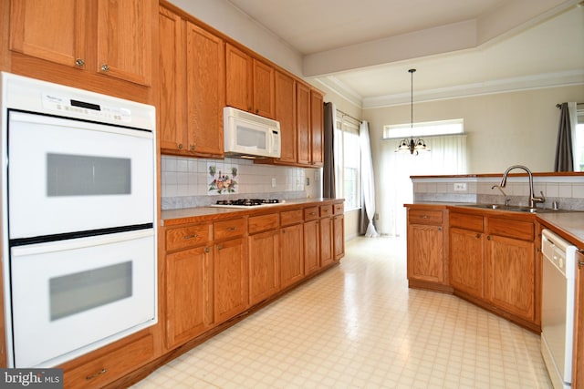 kitchen featuring a notable chandelier, a sink, ornamental molding, white appliances, and light floors