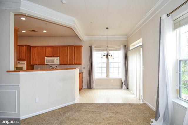 kitchen featuring a chandelier, light carpet, white appliances, crown molding, and brown cabinets