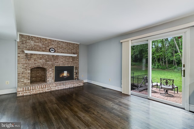 unfurnished living room featuring baseboards, a brick fireplace, and wood finished floors