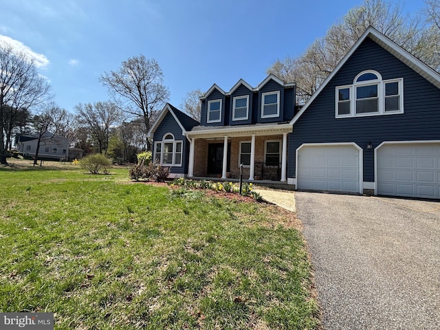 traditional home featuring a porch, brick siding, a front yard, and aphalt driveway