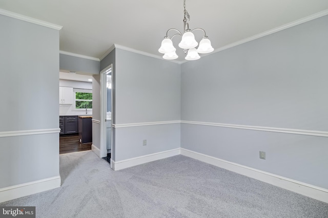 empty room featuring baseboards, a notable chandelier, ornamental molding, and light carpet