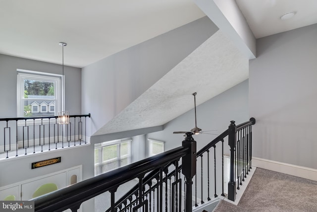 interior space with an upstairs landing, baseboards, and carpet floors