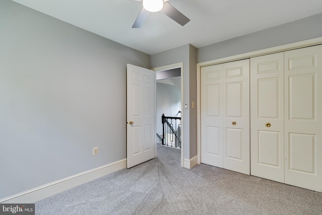 unfurnished bedroom featuring a closet, baseboards, ceiling fan, and carpet floors