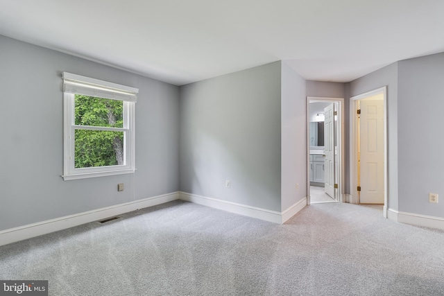 carpeted spare room with baseboards and visible vents