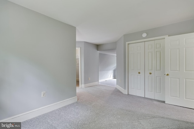 unfurnished bedroom with baseboards, a closet, and carpet