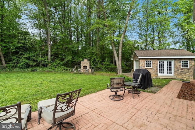 view of patio / terrace with exterior fireplace, french doors, and grilling area