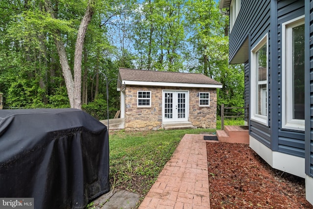 view of yard featuring an outdoor structure and french doors