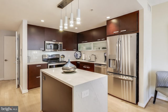 kitchen with light countertops, visible vents, appliances with stainless steel finishes, a sink, and backsplash