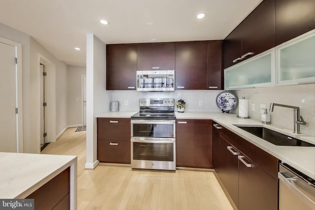 kitchen with light countertops, a sink, stainless steel appliances, and backsplash