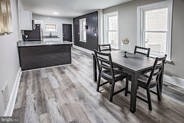 dining space with baseboards, visible vents, and wood finished floors