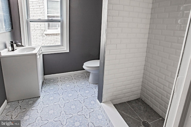 full bath featuring a shower stall, baseboards, toilet, and vanity