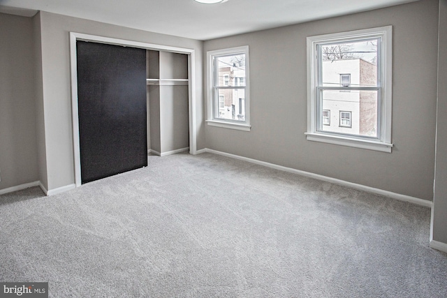 unfurnished bedroom with carpet flooring, baseboards, and a closet