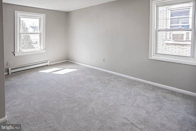 empty room with a baseboard radiator, cooling unit, baseboards, and carpet flooring