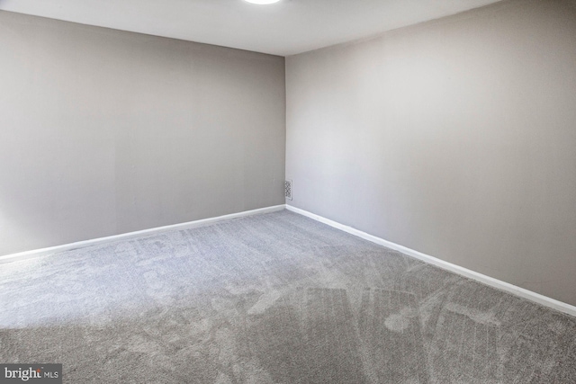 carpeted spare room with baseboards