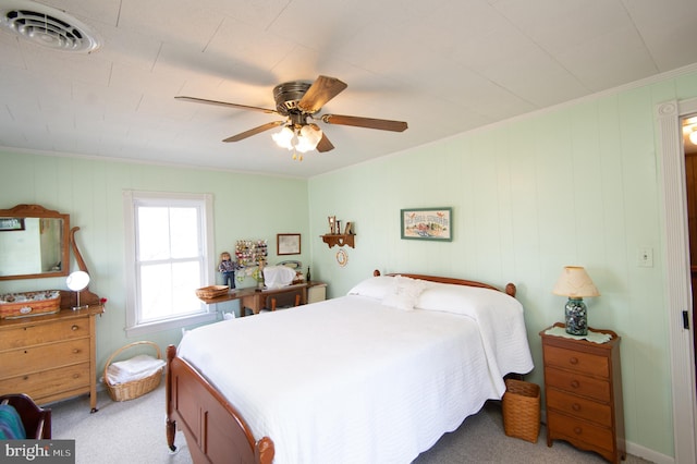carpeted bedroom featuring ornamental molding, ceiling fan, and visible vents