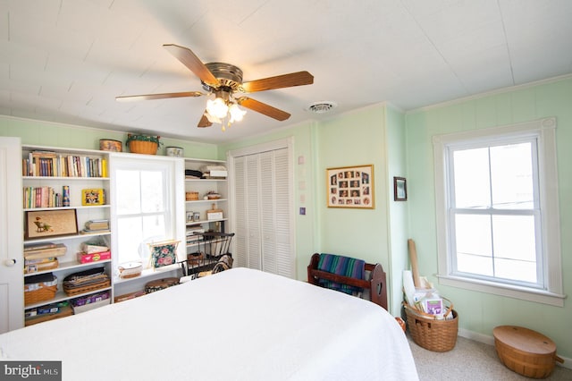 carpeted bedroom featuring a closet, ceiling fan, and visible vents