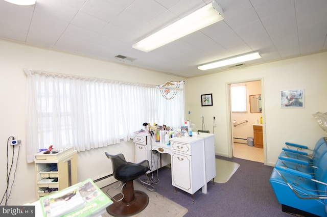 carpeted office space featuring a baseboard radiator and visible vents