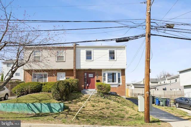 view of front of home with brick siding and fence