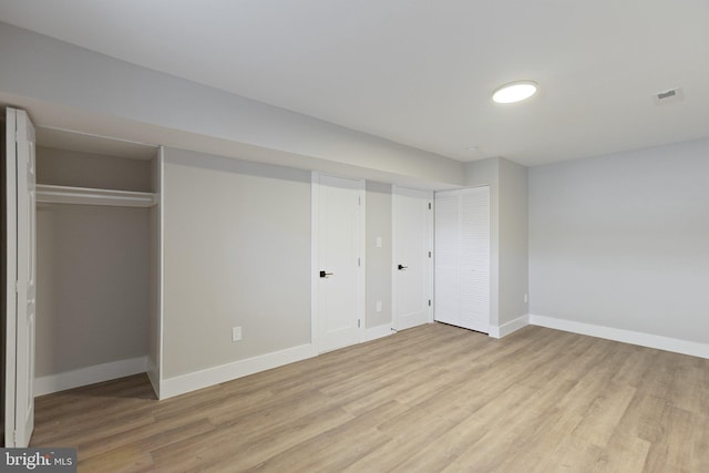 unfurnished bedroom featuring visible vents, baseboards, and wood finished floors