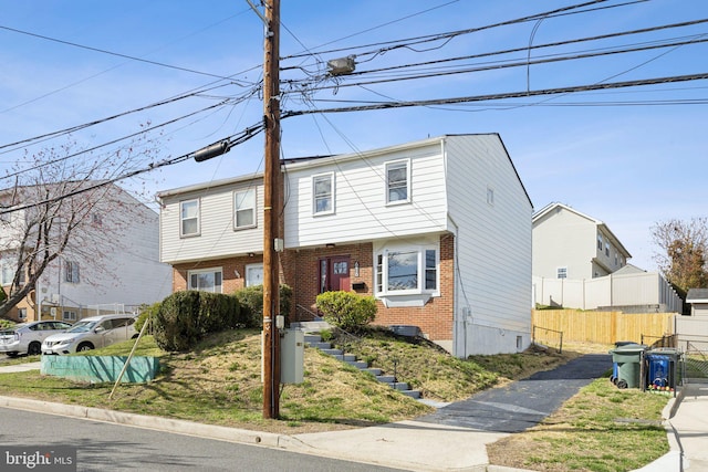 townhome / multi-family property with brick siding and fence