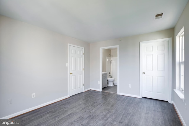 1055 Gardenview Loop Unit 402, Woodbridge, VA 22191 - unfurnished bedroom featuring visible vents, baseboards, ensuite bath, and dark wood-style floors