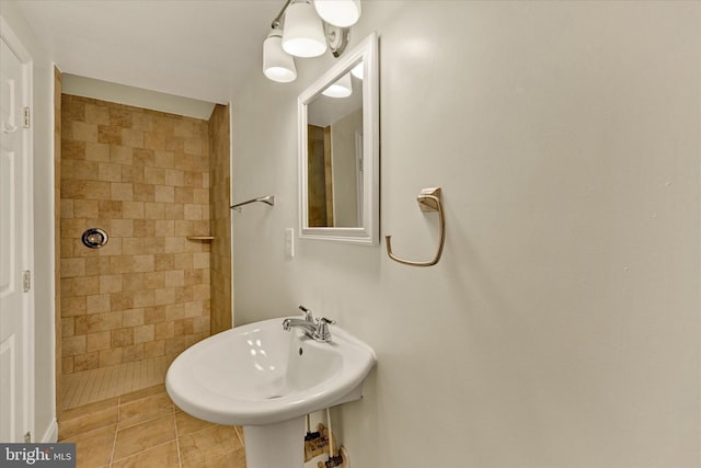 bathroom with tile patterned floors, a sink, and tiled shower