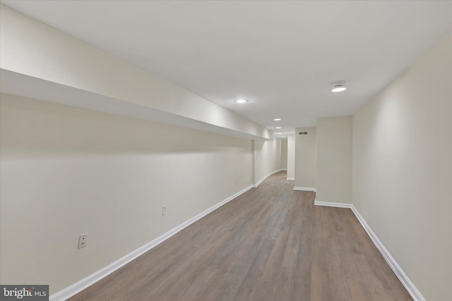 finished below grade area featuring baseboards, visible vents, wood finished floors, and recessed lighting