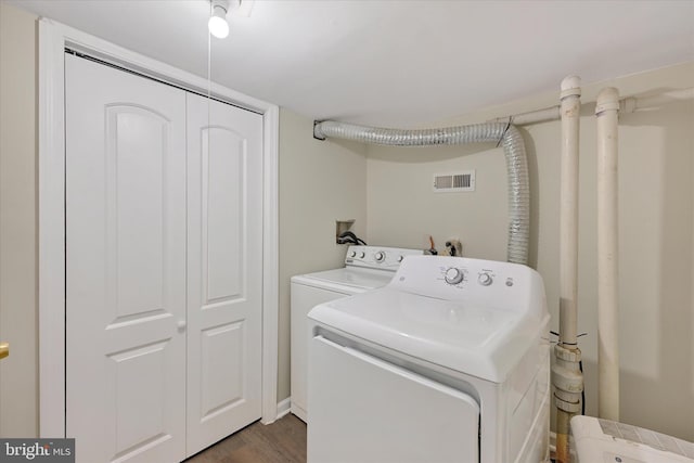 laundry area with dark wood-style floors, visible vents, washer and dryer, and laundry area