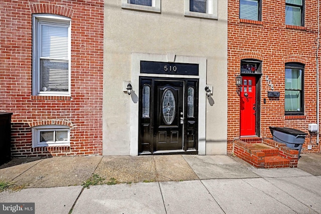 entrance to property with stucco siding and brick siding