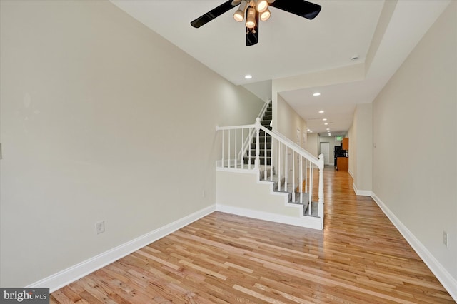 staircase featuring baseboards, ceiling fan, wood finished floors, and recessed lighting