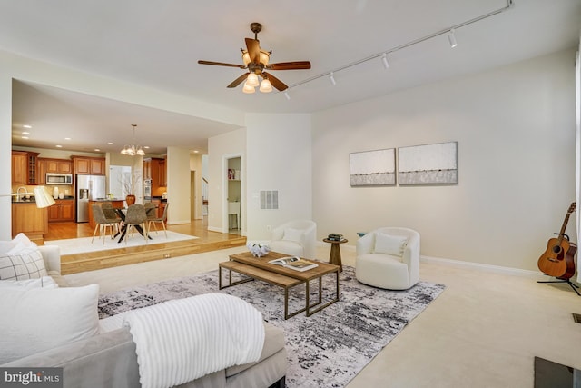 living room with visible vents, rail lighting, baseboards, ceiling fan with notable chandelier, and recessed lighting