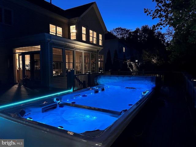 view of swimming pool featuring a sunroom, a hot tub, and a pool